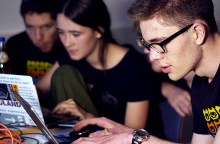 Drei Teilnehmer und eine Teilnehmerin arbeiten gemeinsam währen der Umsetzungsphase beim Ulmer Event zusammen an ihren Laptops.