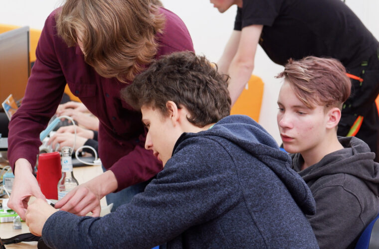 Drei Teilnehmer arbeiten gemeinsam an ihrem Projekt.