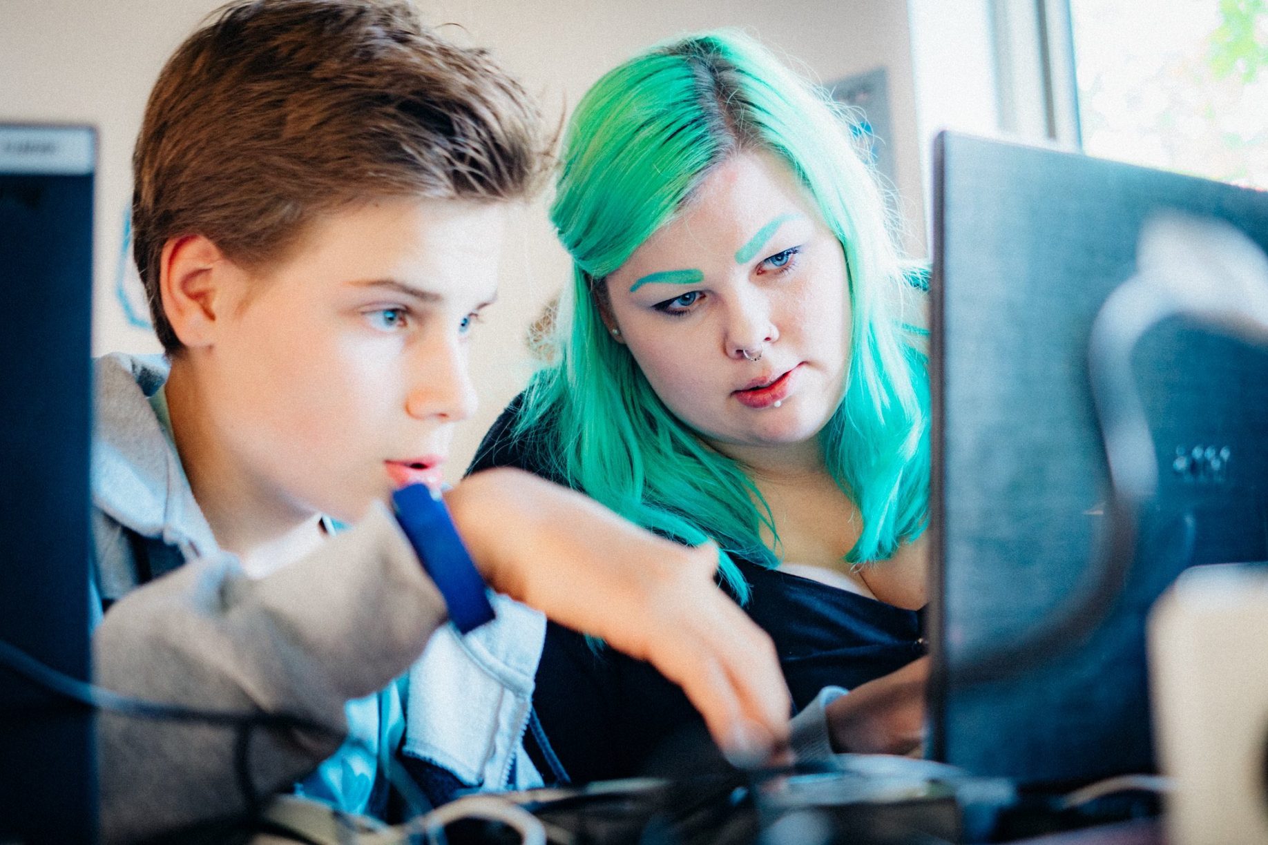 Eine Mentorin und ein Teilnehmer vor ihren Laptops.