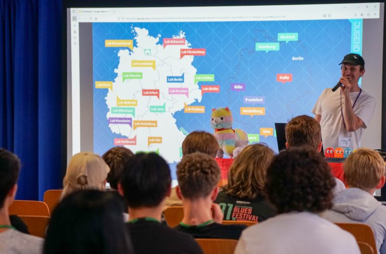 Person stellt die Jugend-hackt-Event- und Lab-Karte einem Publikum vor.